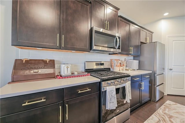 kitchen with tasteful backsplash, dark hardwood / wood-style flooring, appliances with stainless steel finishes, and dark brown cabinetry