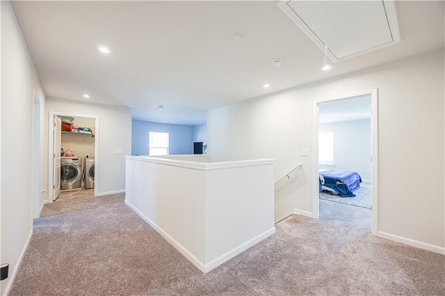 hallway with light carpet and washer and clothes dryer