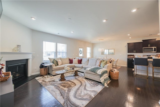 living room with dark wood-type flooring and an inviting chandelier