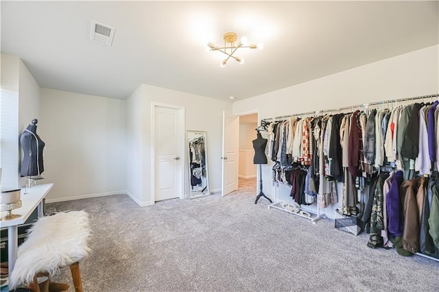 walk in closet with light carpet