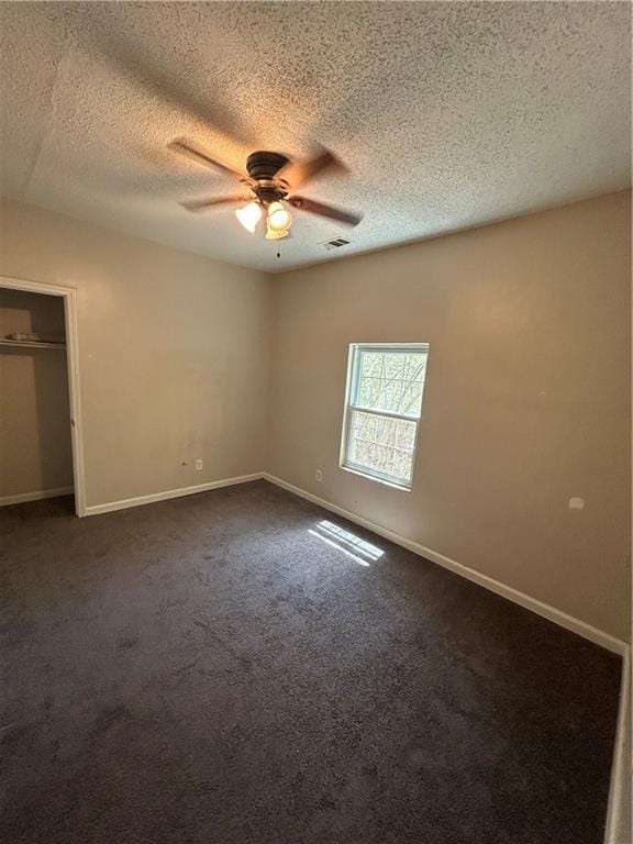 1182 Sims St SW, Atlanta, GA 30310 - unfurnished bedroom with dark colored carpet, a textured ceiling, baseboards, ceiling fan, and a closet