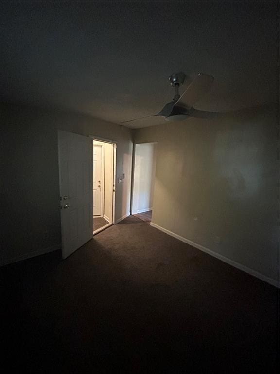 1182 Sims St SW, Atlanta, GA 30310 - empty room with dark colored carpet, baseboards, and ceiling fan