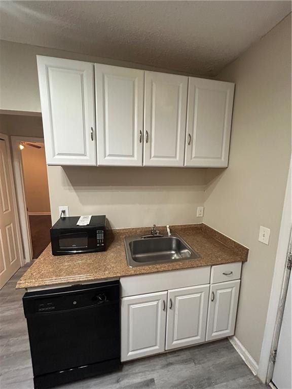 1182 Sims St SW, Atlanta, GA 30310 - kitchen with black appliances, a sink, white cabinetry, wood finished floors, and baseboards