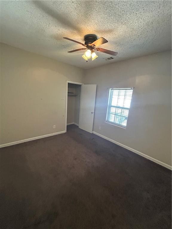 1182 Sims St SW, Atlanta, GA 30310 - unfurnished bedroom featuring baseboards, a textured ceiling, dark colored carpet, a closet, and ceiling fan
