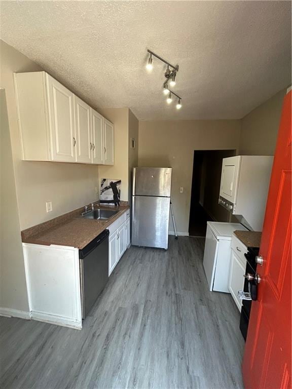 1182 Sims St SW, Atlanta, GA 30310 - kitchen with stainless steel appliances, a textured ceiling, a sink, light wood-style flooring, and white cabinets