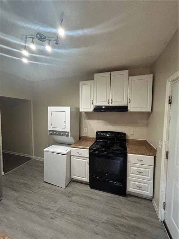1182 Sims St SW, Atlanta, GA 30310 - kitchen with black range, stacked washing machine and dryer, under cabinet range hood, light wood-type flooring, and white cabinets