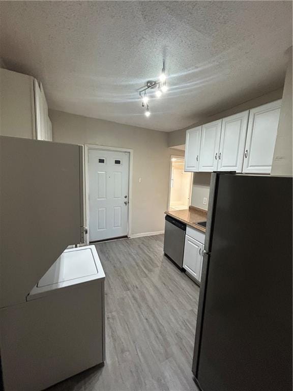 1182 Sims St SW, Atlanta, GA 30310 - kitchen with freestanding refrigerator, stainless steel dishwasher, light wood finished floors, white cabinets, and a textured ceiling