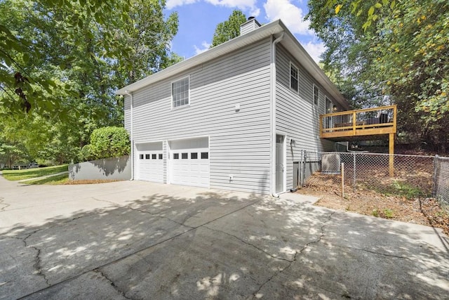 view of home's exterior featuring a garage and a wooden deck