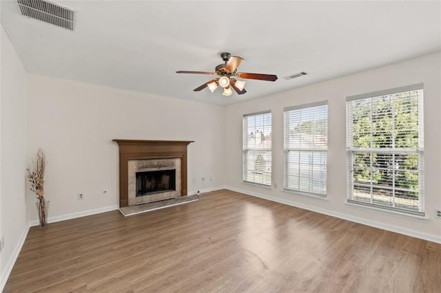 unfurnished living room with a wealth of natural light, wood finished floors, and visible vents