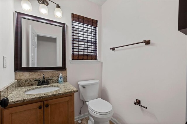 half bathroom with toilet and vanity