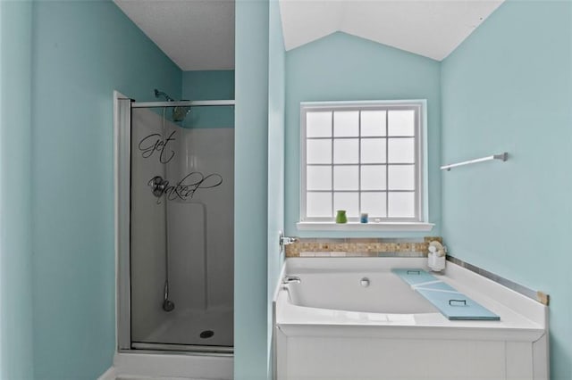 bathroom with a stall shower, vaulted ceiling, and a bath