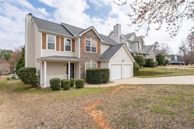 traditional home featuring concrete driveway, stone siding, a chimney, covered porch, and a front yard