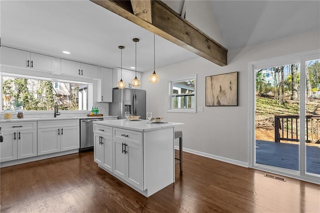 kitchen with backsplash, a healthy amount of sunlight, visible vents, and appliances with stainless steel finishes