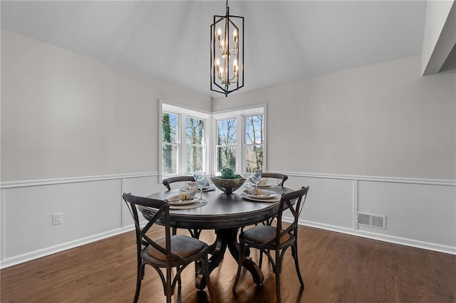 dining room featuring visible vents, wood finished floors, an inviting chandelier, baseboards, and vaulted ceiling