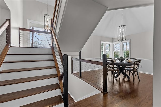 interior space featuring a notable chandelier, lofted ceiling, baseboards, and wood finished floors