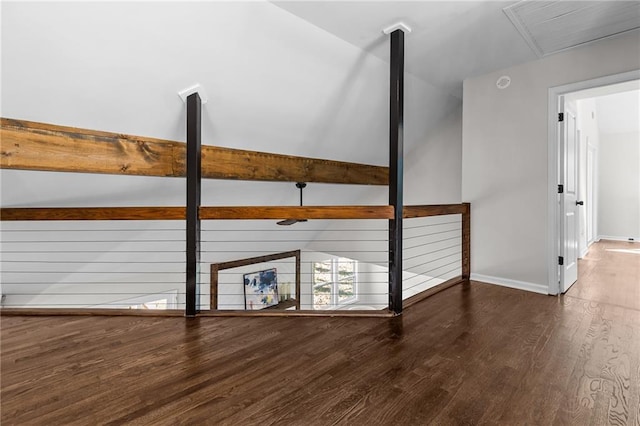 interior space with vaulted ceiling with beams, wood finished floors, and baseboards