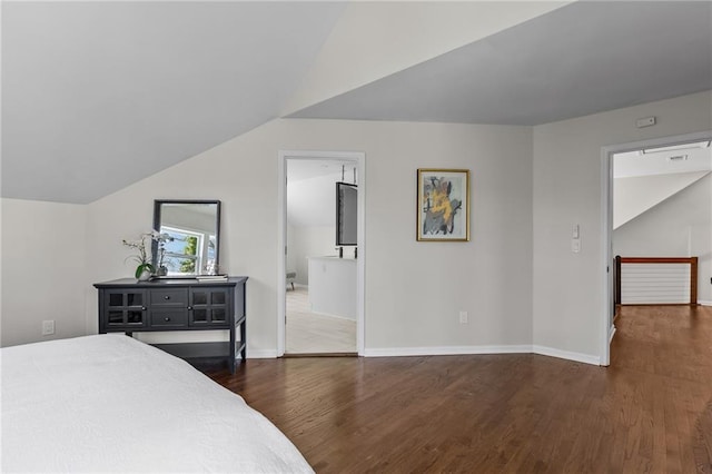 bedroom featuring dark wood finished floors, baseboards, and lofted ceiling