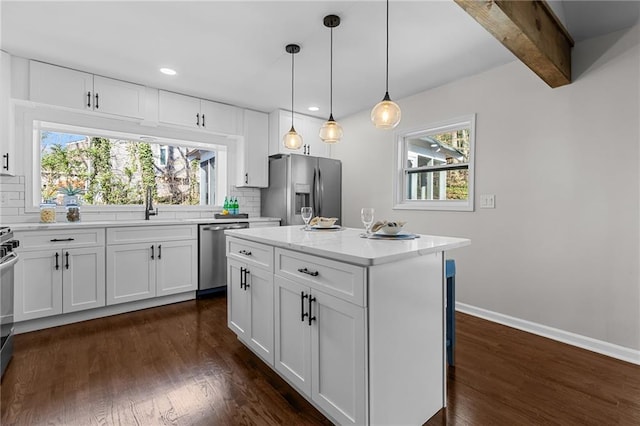 kitchen with tasteful backsplash, dark wood finished floors, white cabinetry, appliances with stainless steel finishes, and baseboards