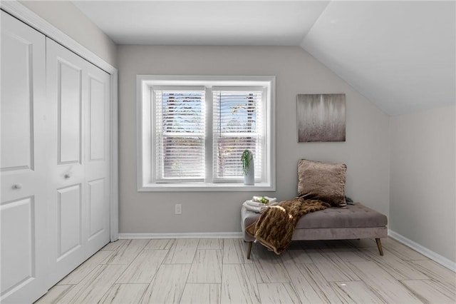 sitting room featuring baseboards and lofted ceiling