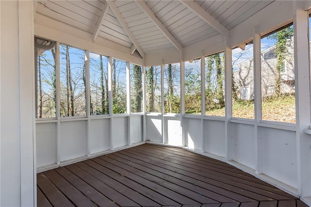 unfurnished sunroom featuring vaulted ceiling with beams