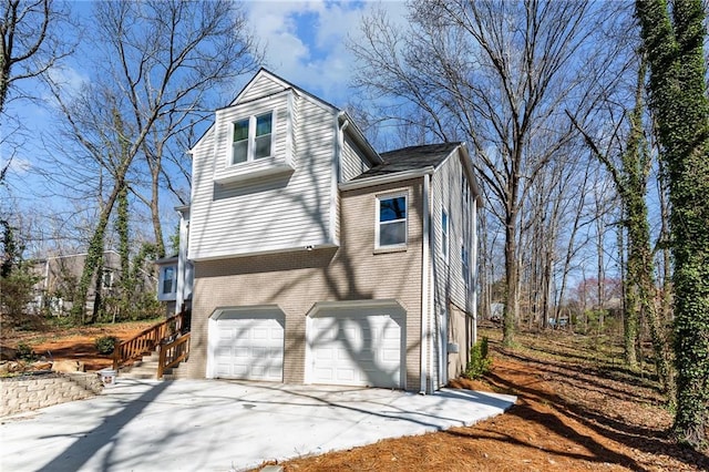 view of home's exterior featuring brick siding, an attached garage, and driveway