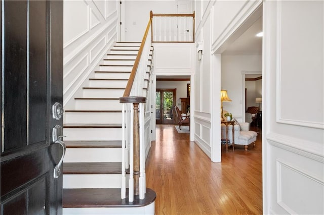 foyer with crown molding and light hardwood / wood-style flooring