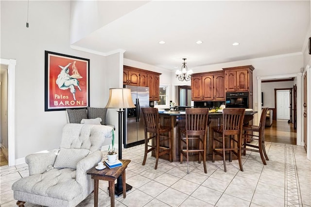 tiled dining space featuring ornamental molding and a chandelier