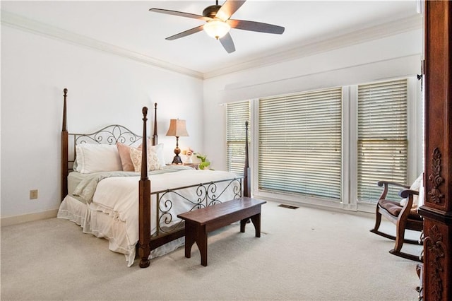 carpeted bedroom with ornamental molding and ceiling fan