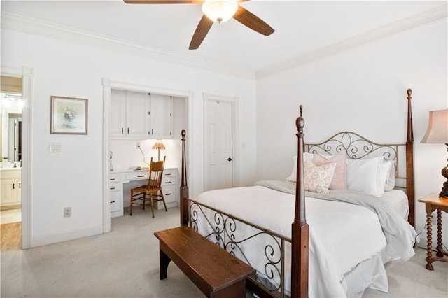 bedroom featuring ornamental molding, light carpet, built in desk, and ceiling fan