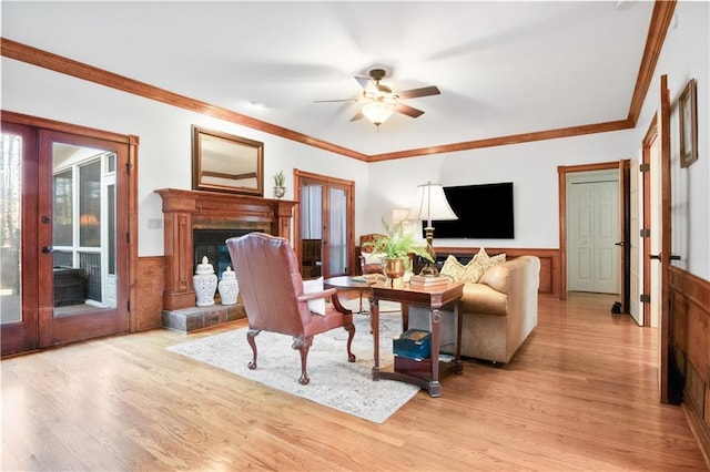 living room featuring crown molding, light hardwood / wood-style floors, and french doors