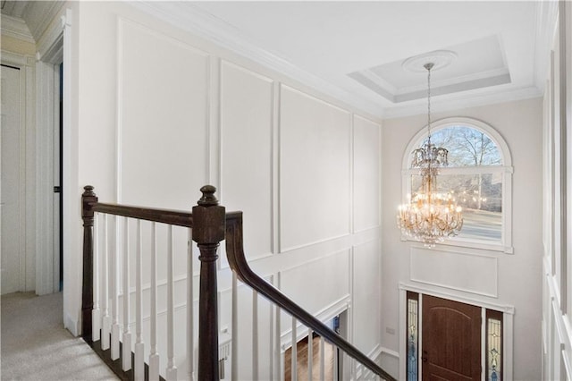 interior space featuring a notable chandelier, a tray ceiling, and ornamental molding