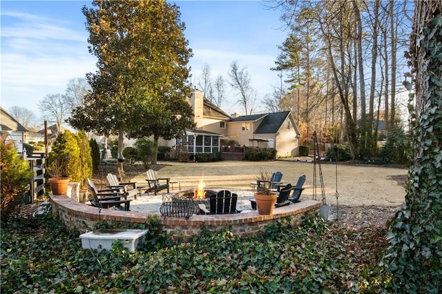 view of yard with an outdoor fire pit, a patio, and a sunroom