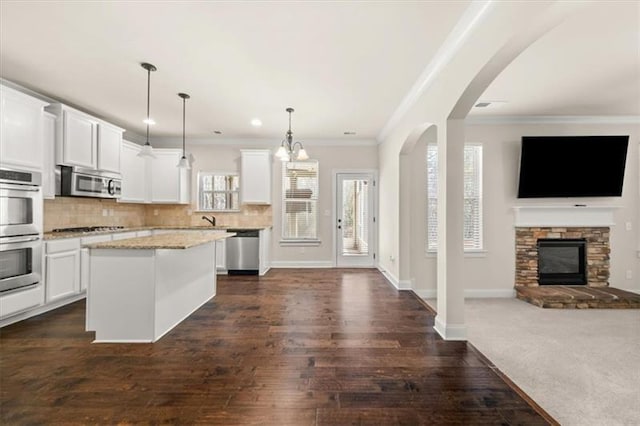 kitchen featuring stainless steel appliances, white cabinetry, and open floor plan