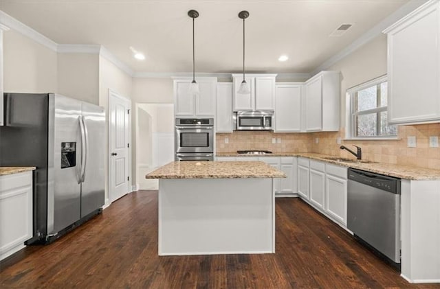 kitchen with crown molding, decorative backsplash, a center island, and stainless steel appliances
