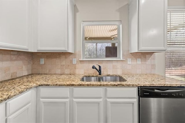 kitchen featuring a sink, decorative backsplash, white cabinets, and stainless steel dishwasher