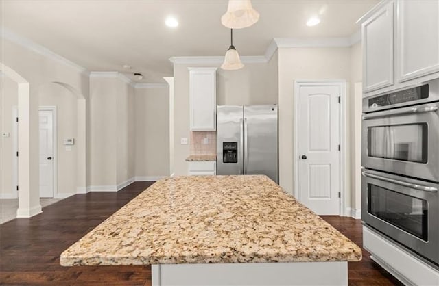 kitchen featuring appliances with stainless steel finishes, ornamental molding, light stone countertops, and white cabinets