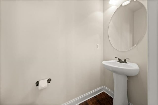 bathroom with baseboards, a sink, and wood finished floors