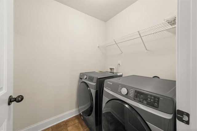 laundry area featuring separate washer and dryer, laundry area, and baseboards