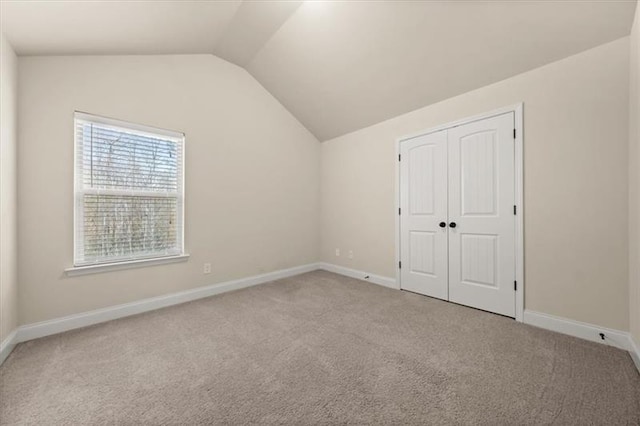 bonus room with carpet floors, baseboards, and vaulted ceiling