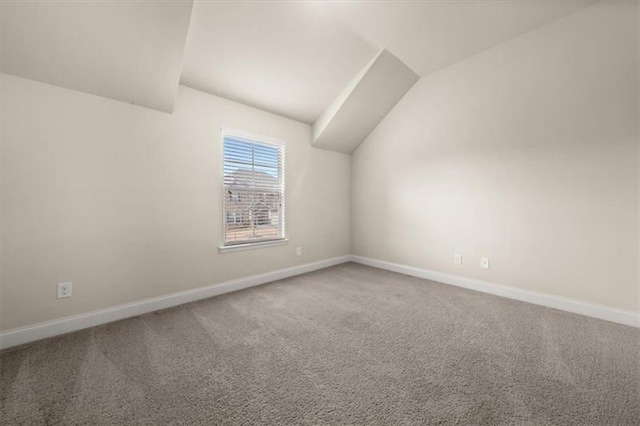 additional living space featuring baseboards, vaulted ceiling, and carpet flooring
