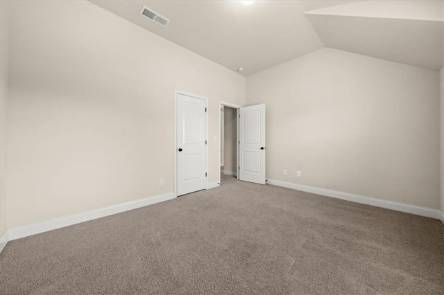 unfurnished room featuring carpet floors, baseboards, lofted ceiling, and visible vents