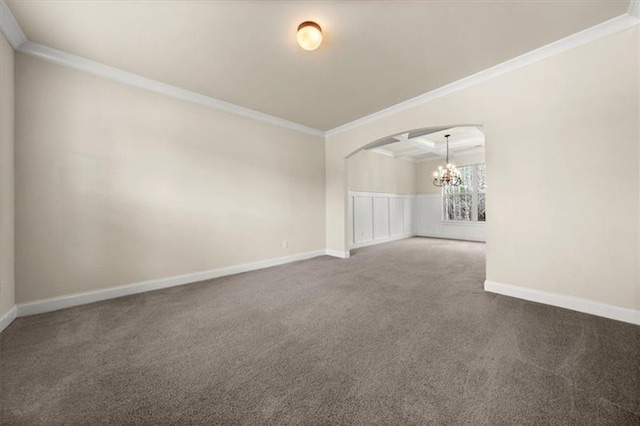 empty room with crown molding, carpet floors, arched walkways, a chandelier, and baseboards