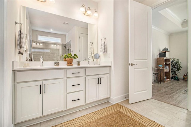 full bathroom featuring a sink, a walk in shower, ornamental molding, and double vanity