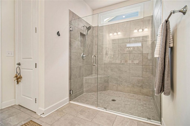 bathroom featuring baseboards, tile patterned flooring, and a stall shower