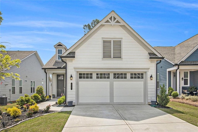 view of front of property with an attached garage, a shingled roof, driveway, and central AC unit