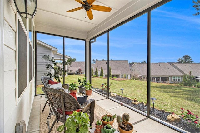 sunroom with ceiling fan and a residential view