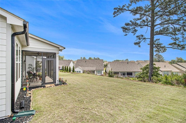 view of yard featuring a residential view and a sunroom