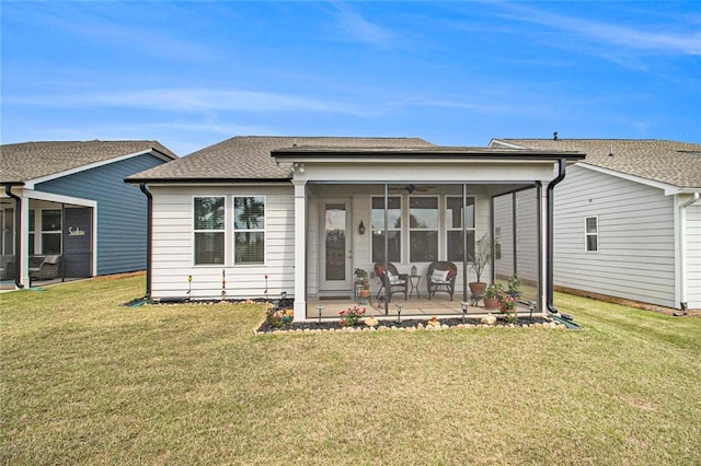 rear view of property with a lawn, a patio, and a sunroom