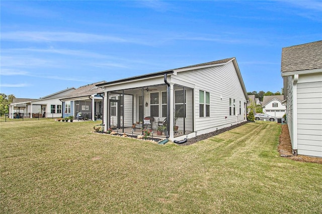back of property featuring a lawn and a sunroom