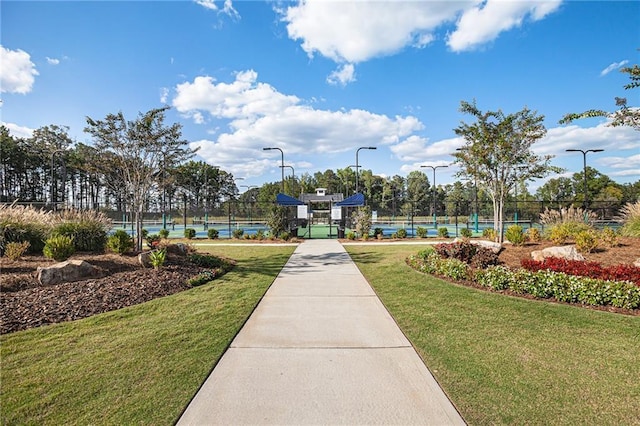 view of property's community with fence and a yard